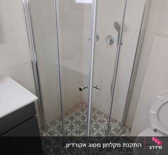 מקלחון פינתי שקוף מותקן בחדר רחצה מעוצב
